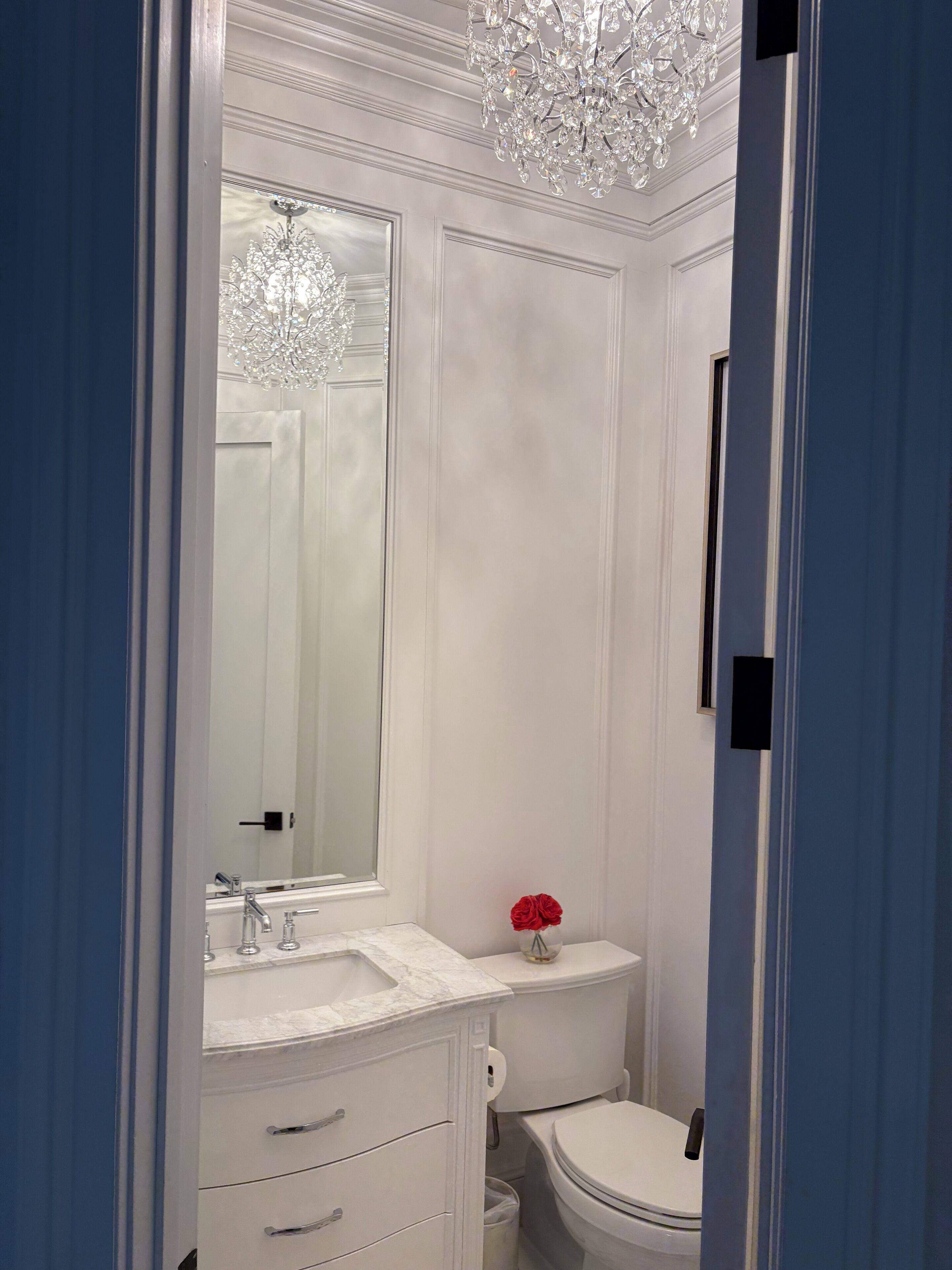 Un bagno con un lavabo in marmo, un water e un lampadario.
