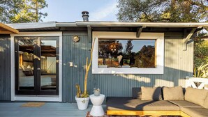 Ein modernes Haus mit Terrasse, großem Fenster und einer Couch.