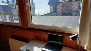 A room with a wooden desk, a laptop, and a lamp. - Hiram - seaside (Fécamp)