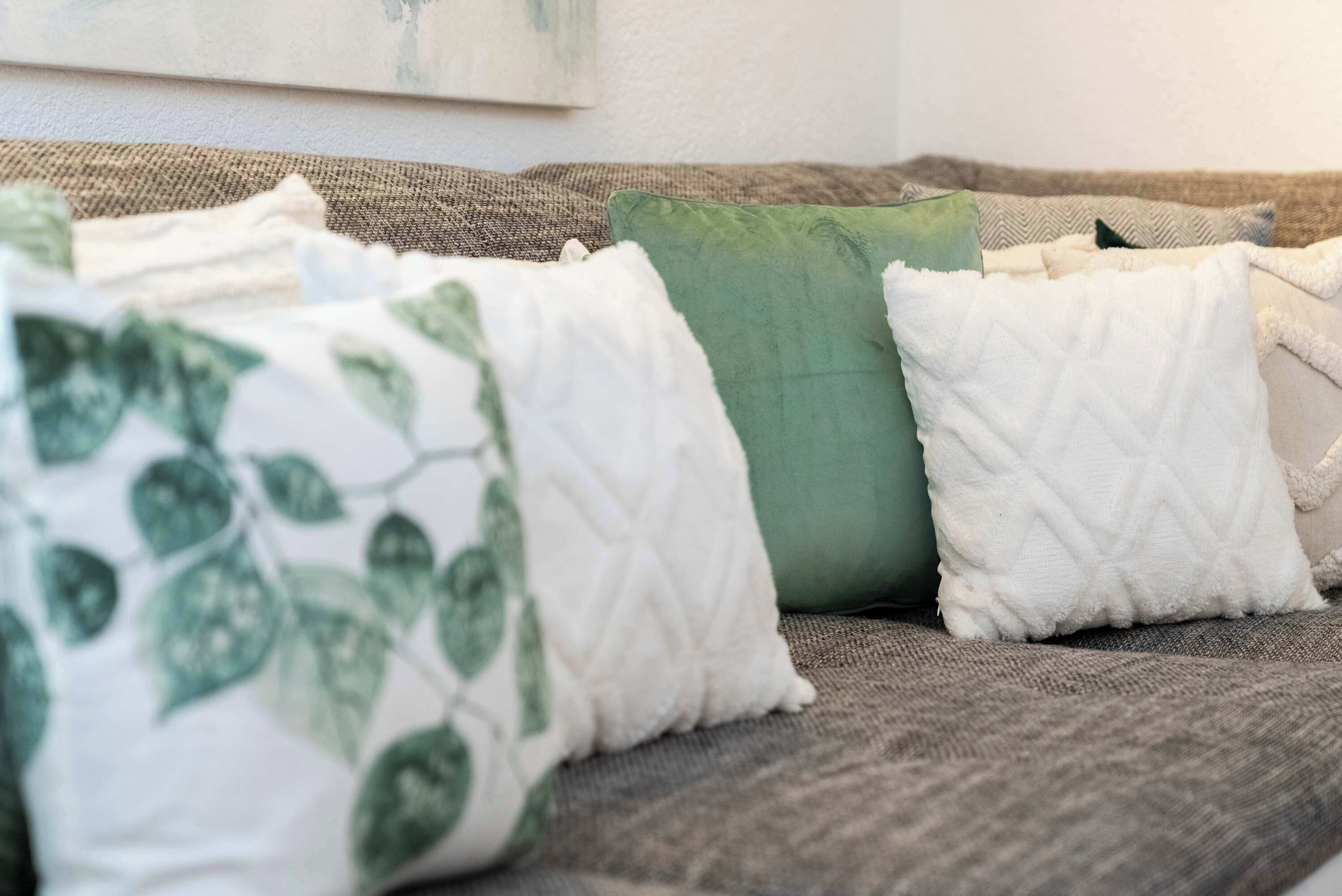 Ein Sofa mit mehreren Kissen in verschiedenen Farben und Mustern.