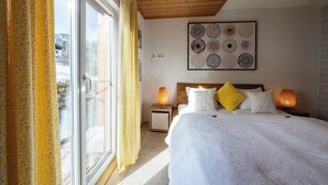 Un dormitorio con una cama grande, cabecera de madera y una obra de arte en la pared.