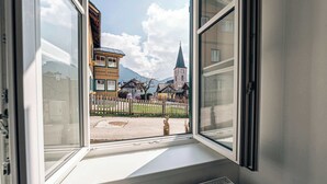 A window with a view of buildings and a church steeple.