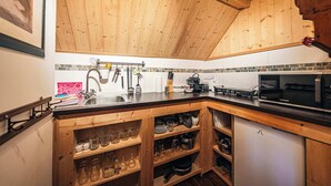 Een keuken met houten kastjes, een zwart aanrecht en een magnetron.