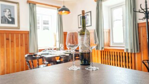 Un comedor con una mesa, dos copas de vino y una botella.