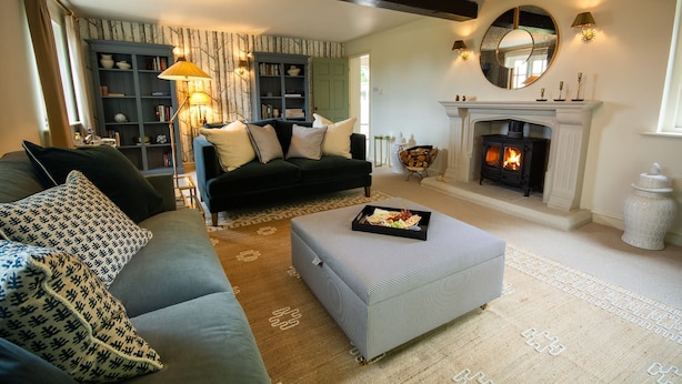 A cozy living room with a fireplace, a sofa, a coffee table, and a bookshelf. - Sandstone 34 - sleeps 6 guests  in 3 bedrooms (Tattenhall, Cheshire)