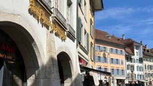Una calle con terraza al aire libre y un edificio con un letrero que dice 'GRAND'.
