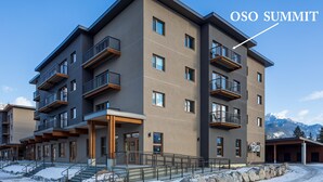 A multi-story building with balconies and a ski slope in the background. - OSO Summit - Downtown Riverfront Condo with Mountain Views (Golden)