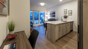 A modern kitchen with wooden cabinets, a built-in island, and a refrigerator. - OSO Summit - Downtown Riverfront Condo with Mountain Views (Golden)