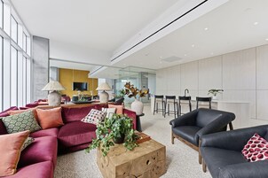 Una sala de estar moderna con un sofá, una mesa de centro y sillas. Hay un comedor con una mesa y sillas.