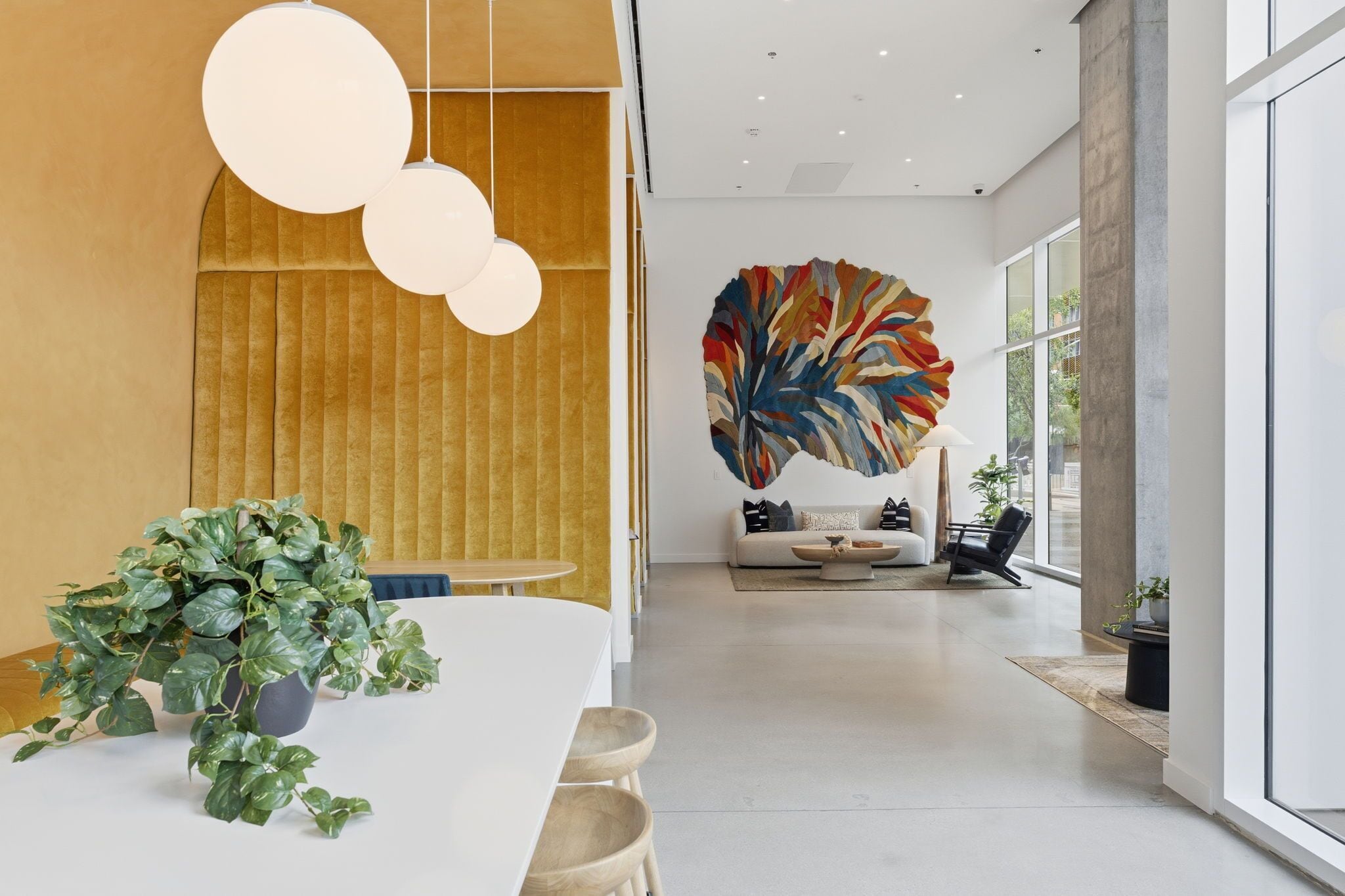 A modern interior with a dining area, a sofa, and a large abstract painting.