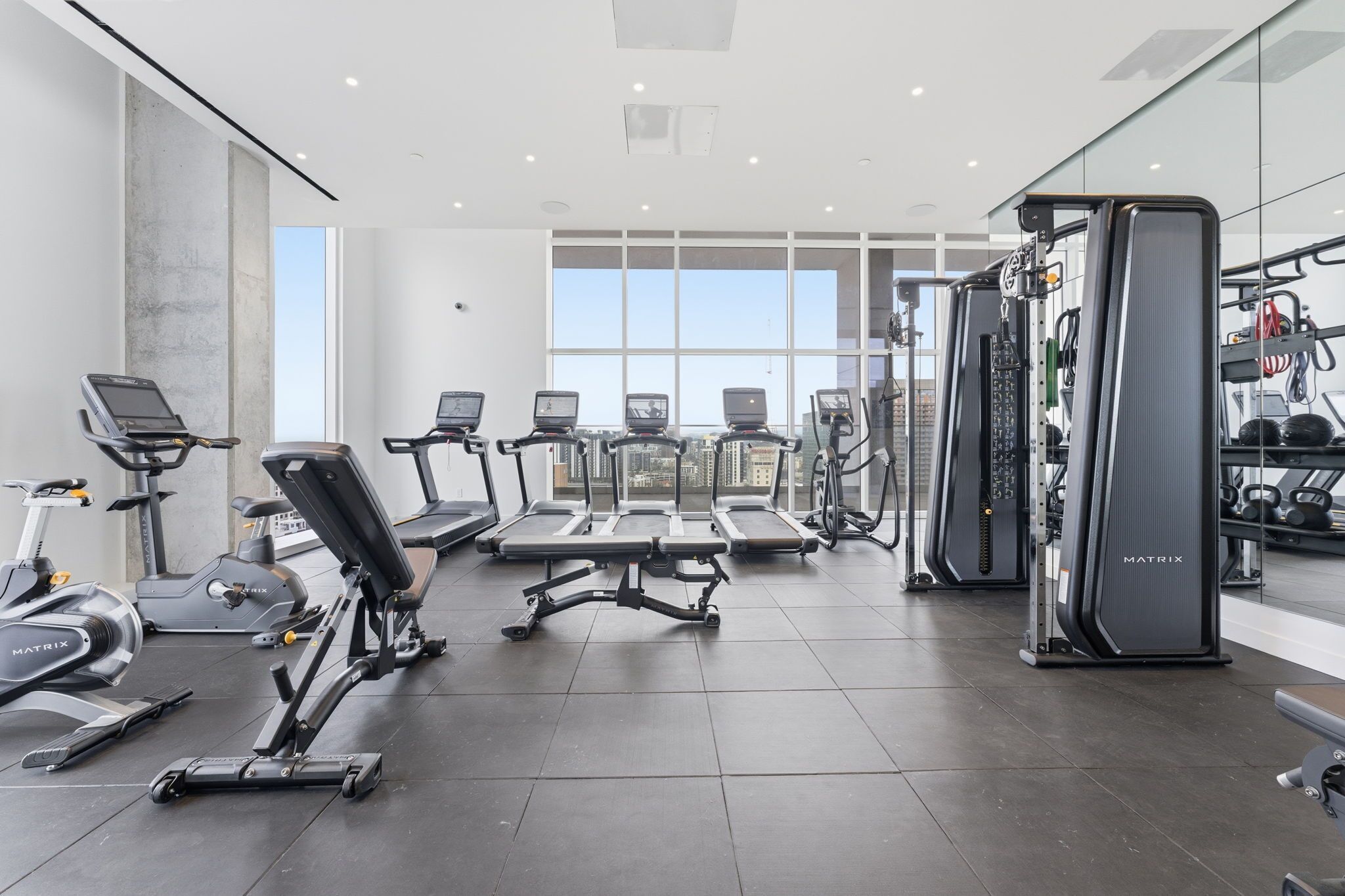 Et moderne fitnesscenter med løbebånd, crosstrainere og styrkeløftudstyr.