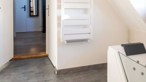 A modern interior with a sloped ceiling, a built-in heater, and a minimalist design.