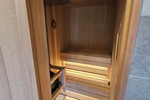 Eine Holzsauna mit Bänken und einer Tür.