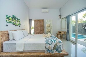 A bedroom with a bed, a wooden headboard, a window with a view of a pool, and a door leading to another room.
