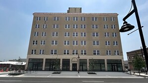 Un immeuble à plusieurs étages doté d’une façade symétrique, de grandes fenêtres et d’une entrée centrale.