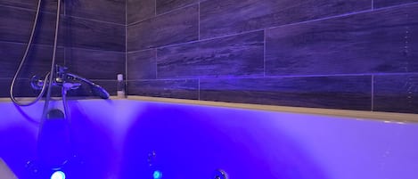Een bubbelbad, een bidet, handdoeken, toiletpapier