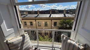 Una habitación con un ventanal que ofrece vistas a edificios y una palmera.