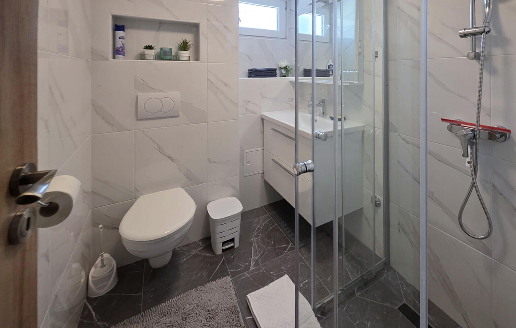 A modern bathroom with a toilet, bidet, and shower.