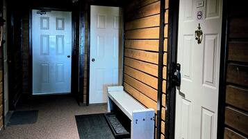 Un couloir avec un banc, une porte portant l’inscription « SORTIE » et une autre porte avec le numéro « 204 ».