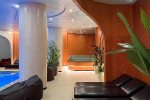 A spa area with a reception desk, a massage chair, and a pool. - Adria Palace (Durres)