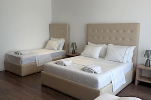 A hotel room with two beds, each with a headboard, a bedside table, and a lamp. - Adria Palace (Durres)