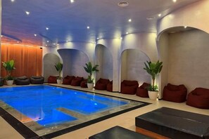 An indoor swimming pool with seating areas and potted plants. - Adria Palace (Durres)