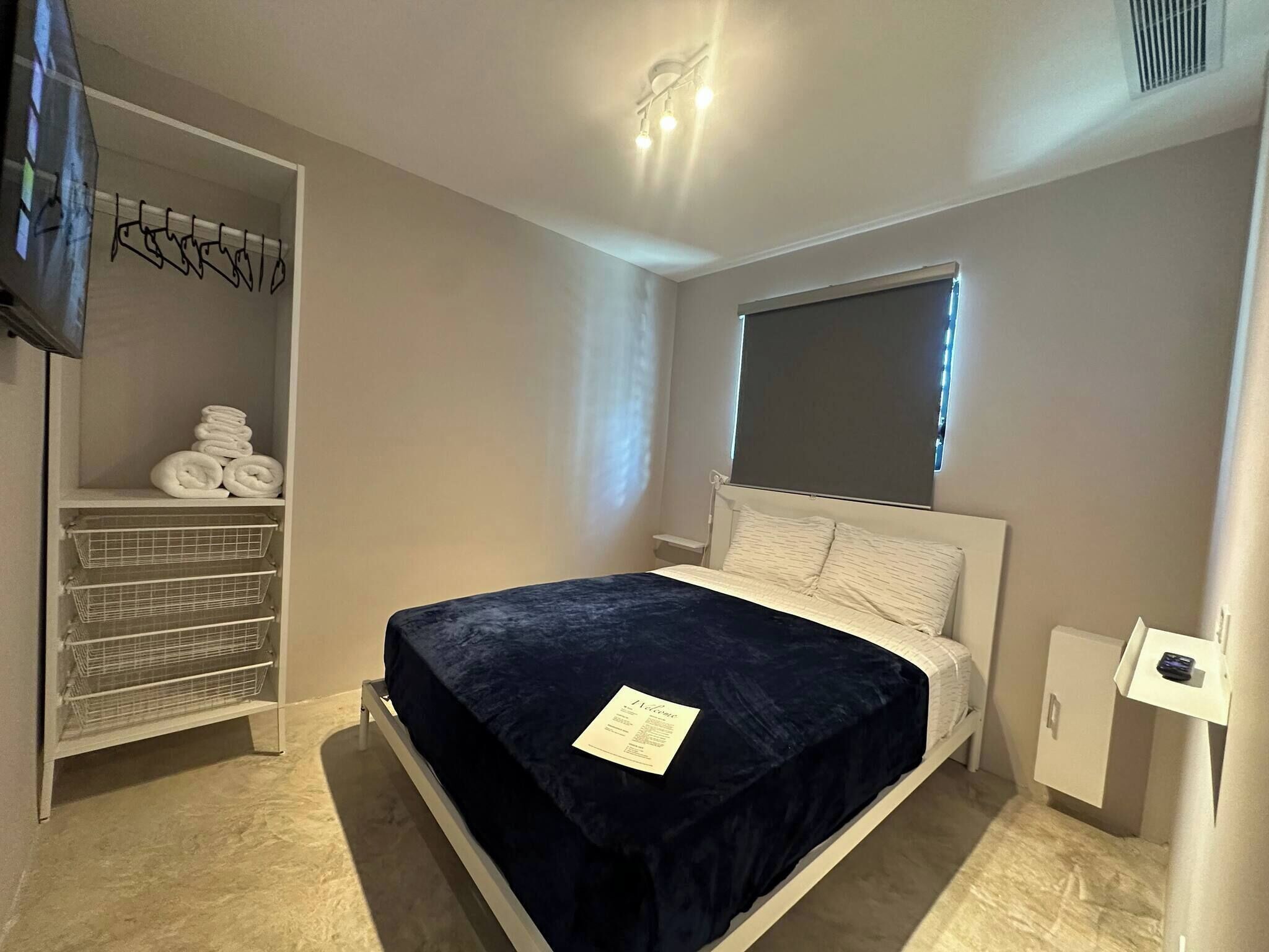 Un dormitorio con una cama, un armario y una ventana.