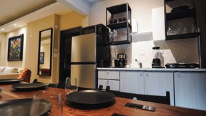 A modern kitchen with a built-in oven, microwave, and coffee maker. There is a dining table with plates and glasses, and a sofa in the background. - Dream apt: 8BD, 6BA, parking. (San Juan)