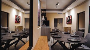 A modern dining area with round tables, benches, and abstract art on the walls. - Dream apt: 8BD, 6BA, parking. (San Juan)