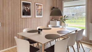 A dining area with a white table, grey and white chairs, a grey pendant lamp, and framed artwork on the wall. - Awesome home in Ebeltoft with WiFi (Ebeltoft)