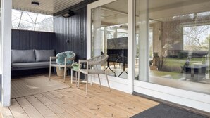 A modern outdoor seating area with a wooden deck, a sofa, and two chairs. - Awesome home in Ebeltoft with WiFi (Ebeltoft)