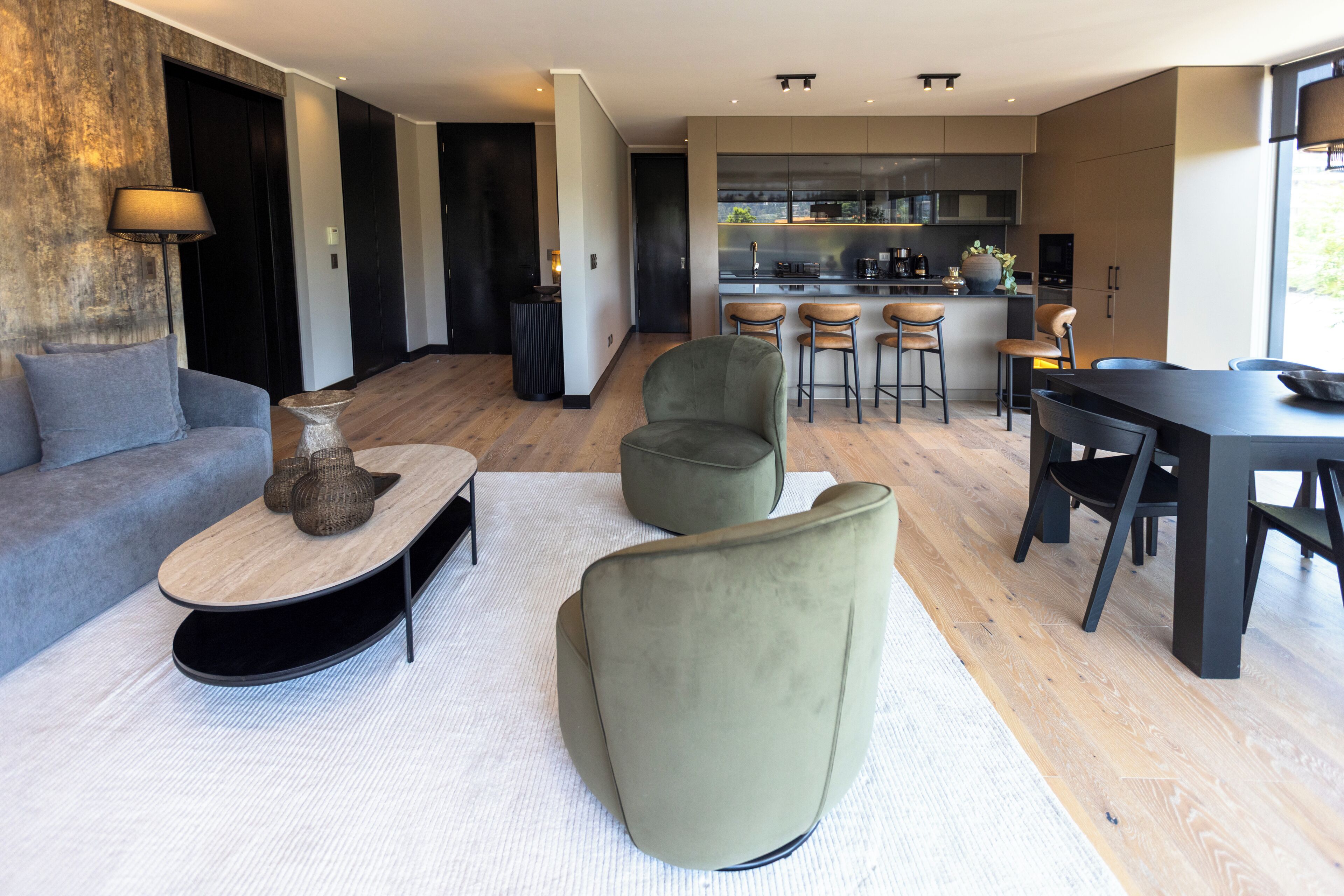 A modern living room with a sofa, a coffee table, and a dining area with chairs and a table.