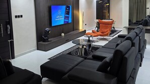 Ein modernes Wohnzimmer mit einer Couch, einem Couchtisch und einem an der Wand befestigten Fernseher.