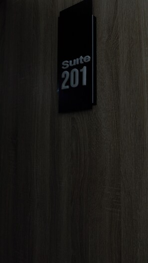 A dark wooden wall with a sign that reads "Suite 201". - H3 Hotel and Events Centre. (Abeokuta)