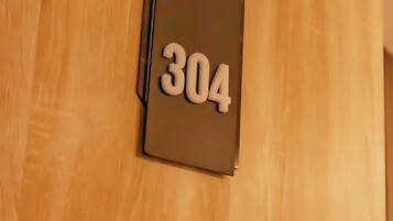 A wooden door with a number plate displaying '304'.