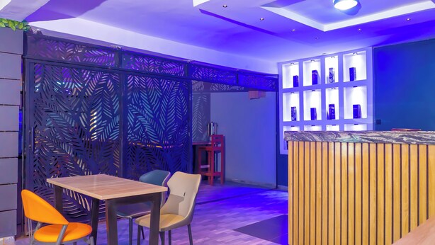 A modern interior with a reception desk, seating area, and display shelves. - H3 Hotel and Events Centre. (Abeokuta)