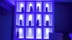 A wall with multiple illuminated display cases, each containing a book. - H3 Hotel and Events Centre. (Abeokuta)