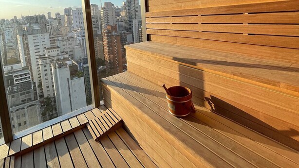 Un interior de madera con un ventanal grande que da a un paisaje urbano.