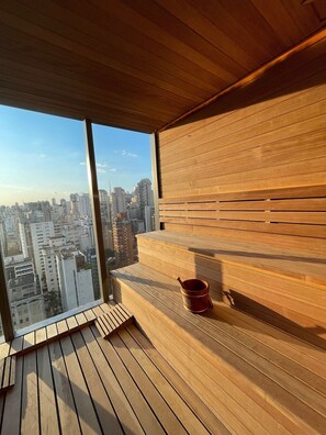 Interior de madeira com uma grande janela com vista para a paisagem urbana.
