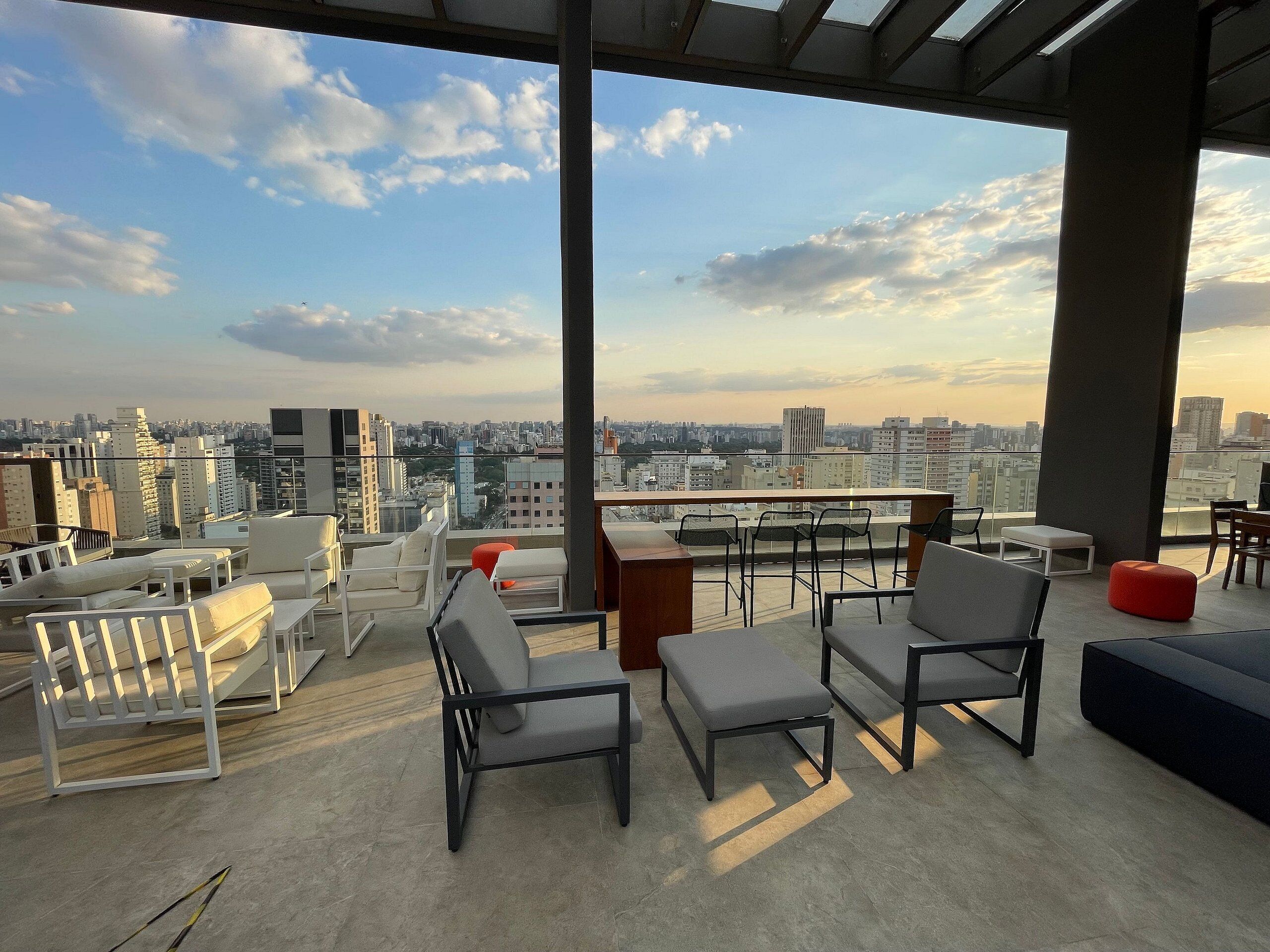 A rooftop terrace with outdoor seating, a city view, and a modern architectural design.