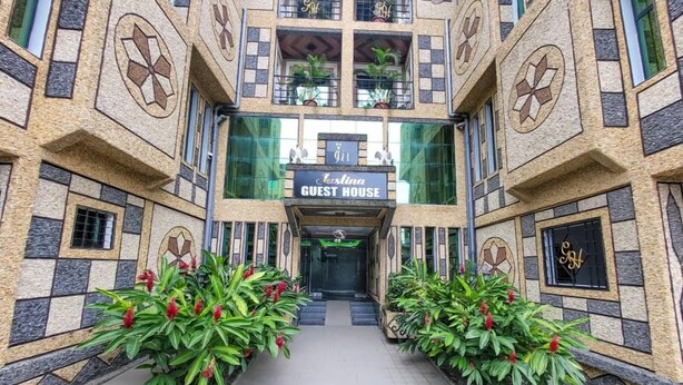 A building with a sign reading "Guest House" and a modern design with geometric patterns and potted plants. - Justina Guest House Hotel  (Douala)