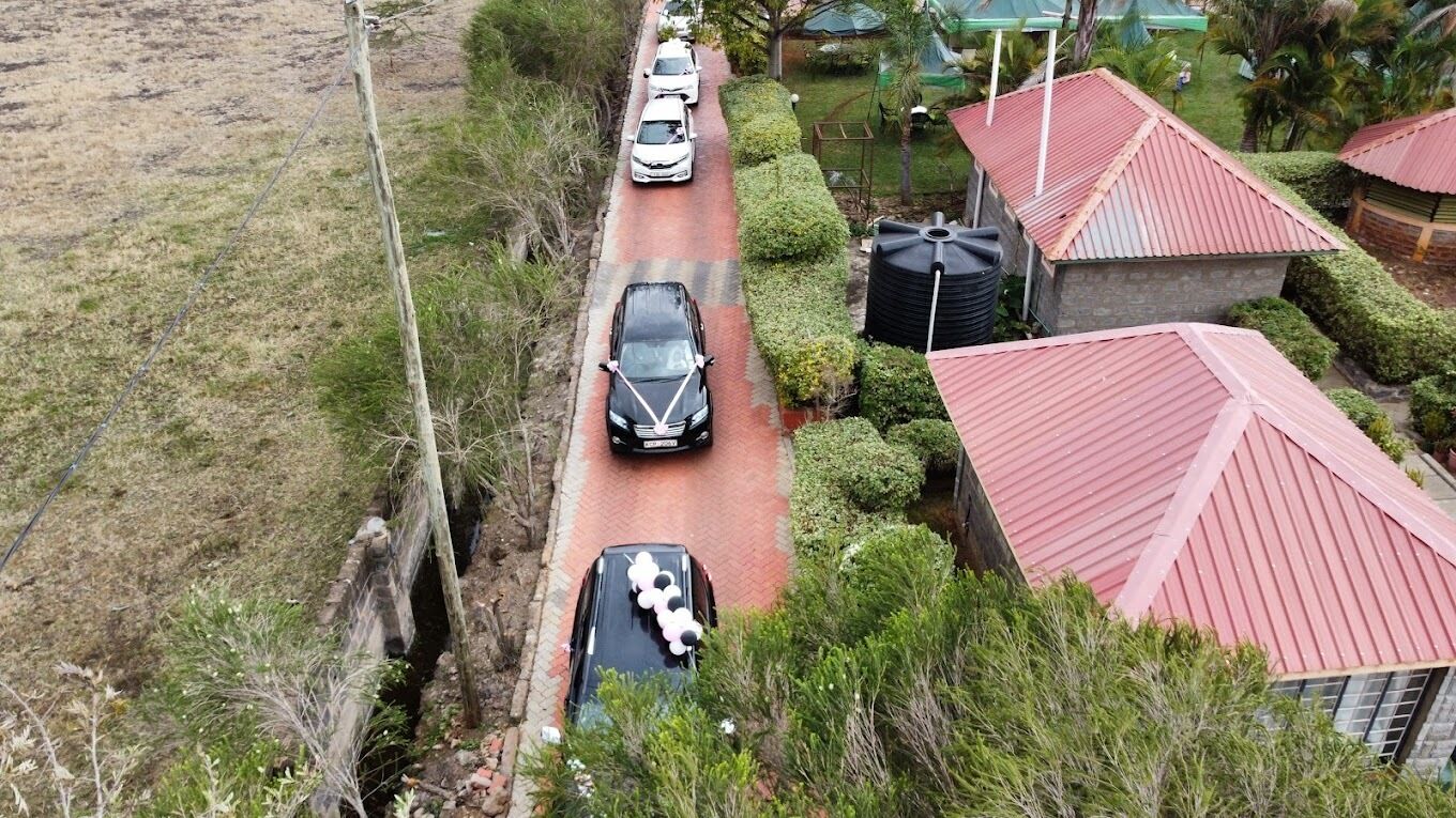 A residential area with a paved road, houses with red roofs, and a water tank.