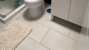 A bathroom with a toilet, sink, and shower.