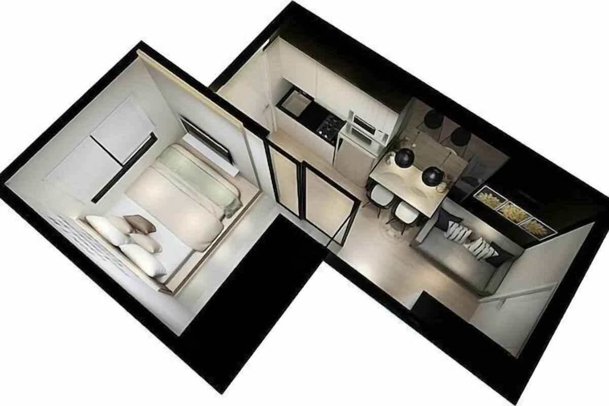 A compact hotel room with a bed, a small sitting area, a kitchenette, and a bathroom.