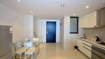 A modern kitchen with a dining area, a refrigerator, and a microwave.