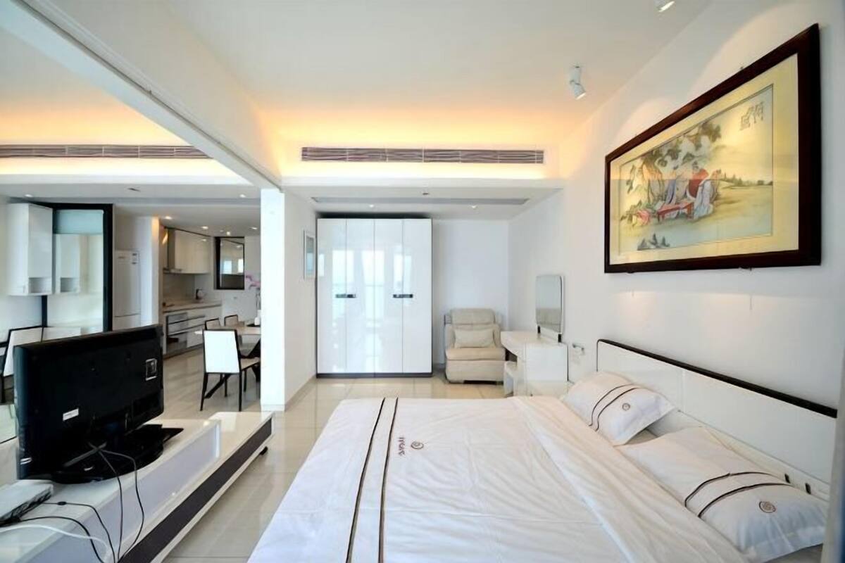 Une chambre d’hôtel avec un lit, un bureau, une chaise, une télévision et un tableau au mur.