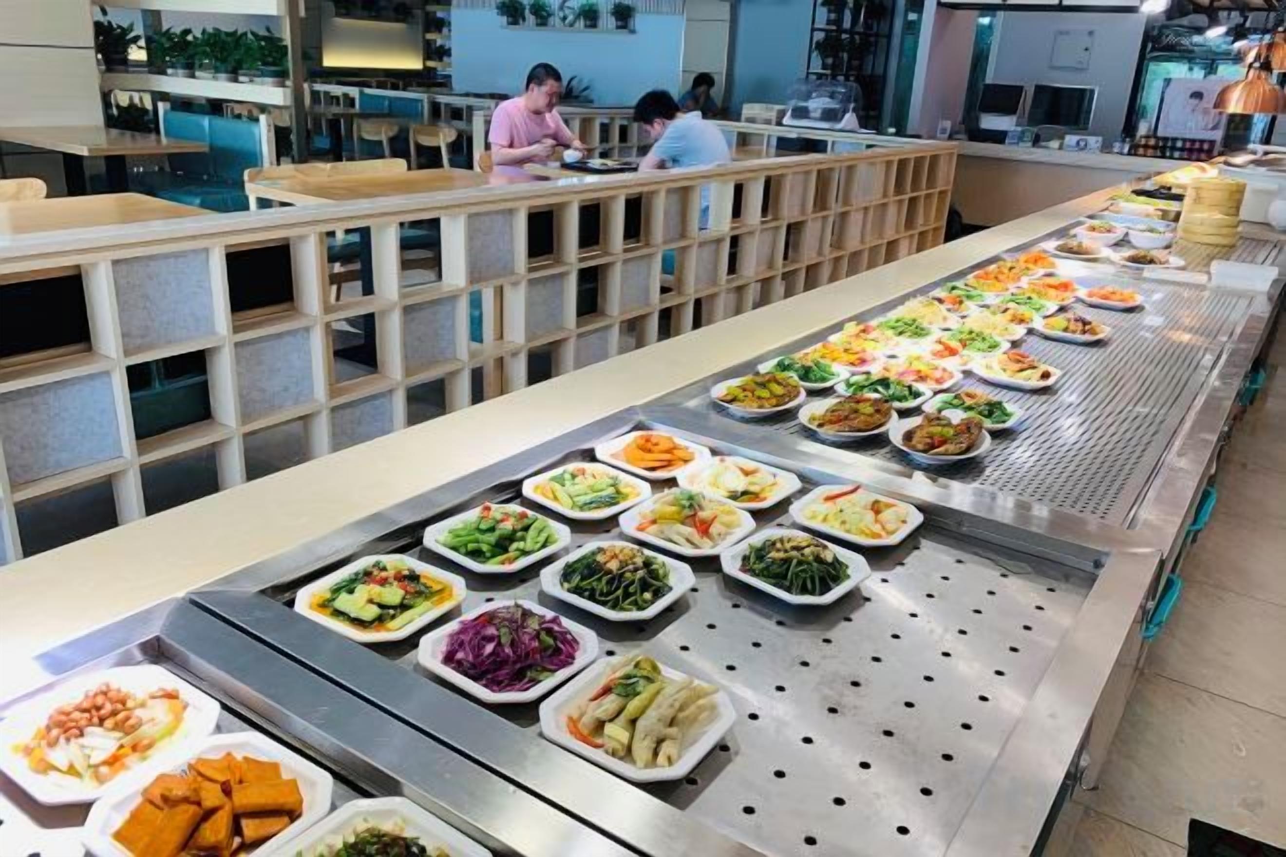 A buffet with various food options arranged on a long table.