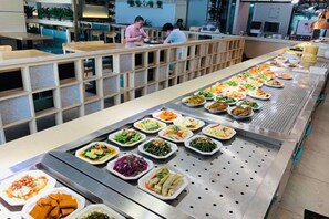 Een buffet met verschillende soorten eten, uitgestald op een lange tafel.