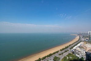 Blick auf die Küste mit Strand, einer Straße und Gebäuden.