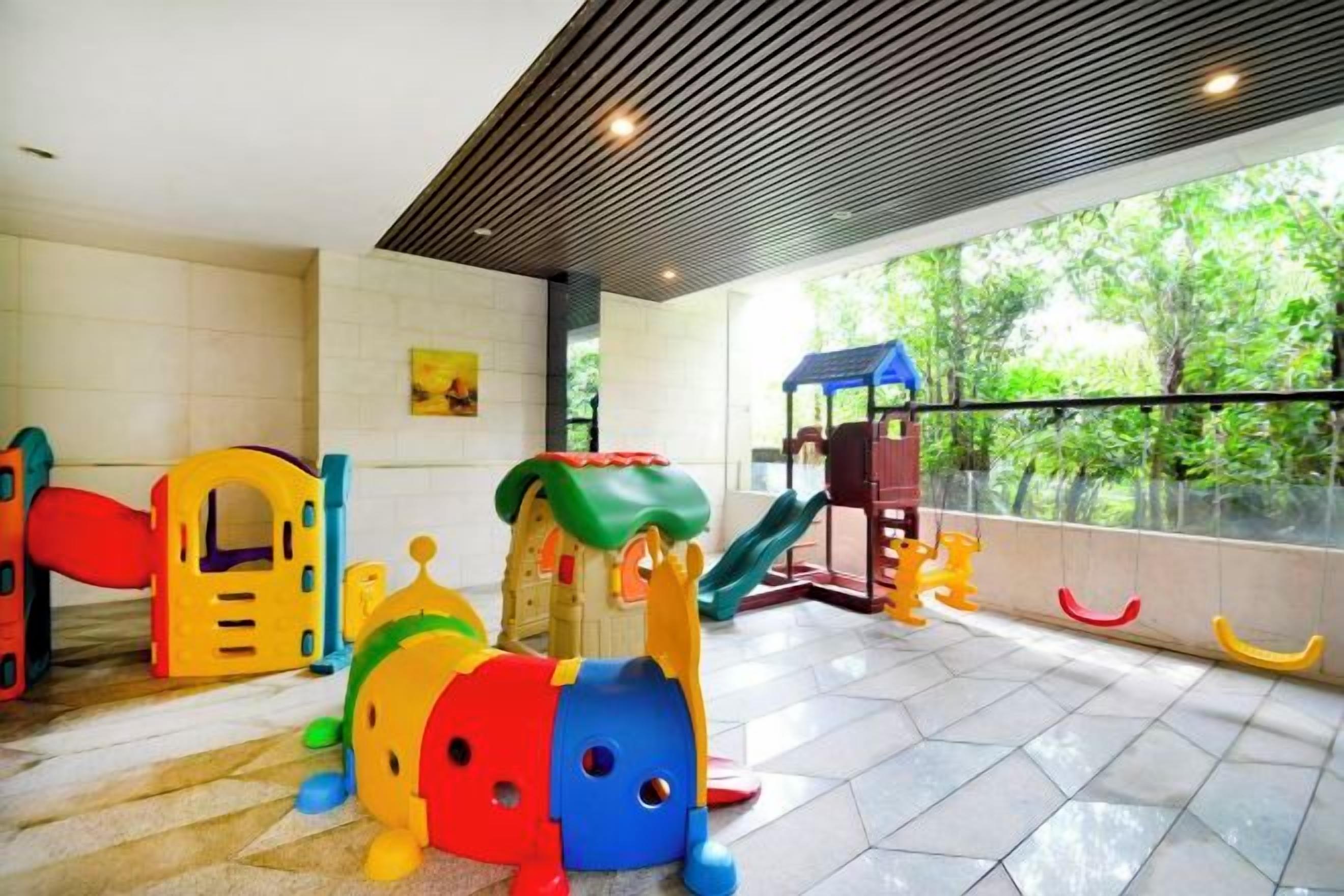 Un área de juegos infantiles con distintas estructuras de recreación y un tobogán.